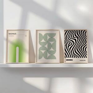 May include: Three framed prints with geometric designs in black, white, and green. The prints are titled "Bauhaus" and feature abstract shapes and patterns.