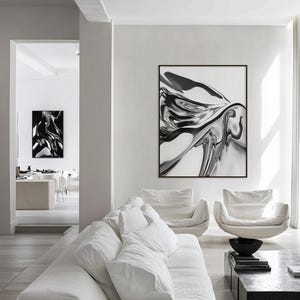 Pode incluir: Uma sala de estar moderna com m&oacute;veis brancos e duas obras de arte abstratas emolduradas em preto e branco. A obra de arte apresenta padr&otilde;es fluidos e rodopiantes. A sala inclui um sof&aacute; branco, duas poltronas e uma mesa de centro.