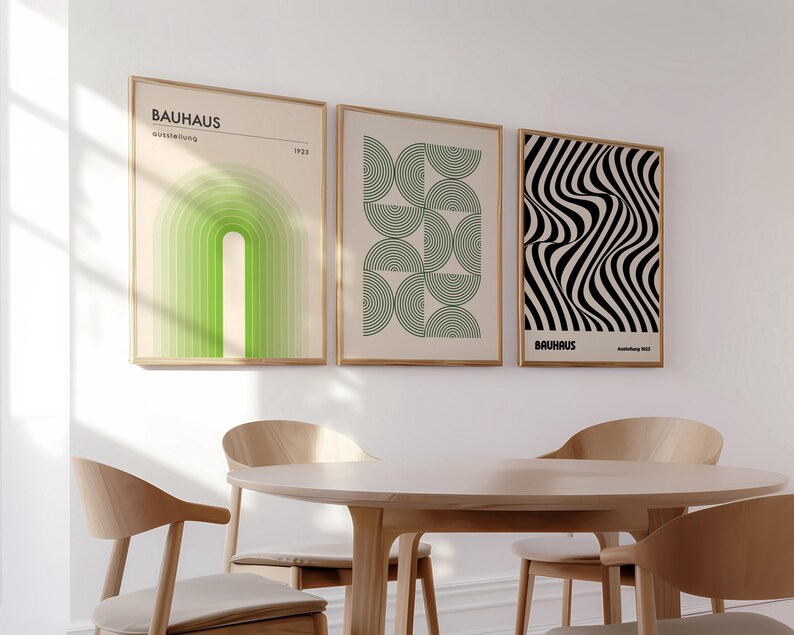 May include: Three framed prints with geometric designs. The prints are in black and white, green and white, and black and white. The prints are hung on a white wall above a wooden table with four chairs.