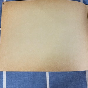 May include: A blank, light brown page with the letters "RT" written in black ink in the top left corner.