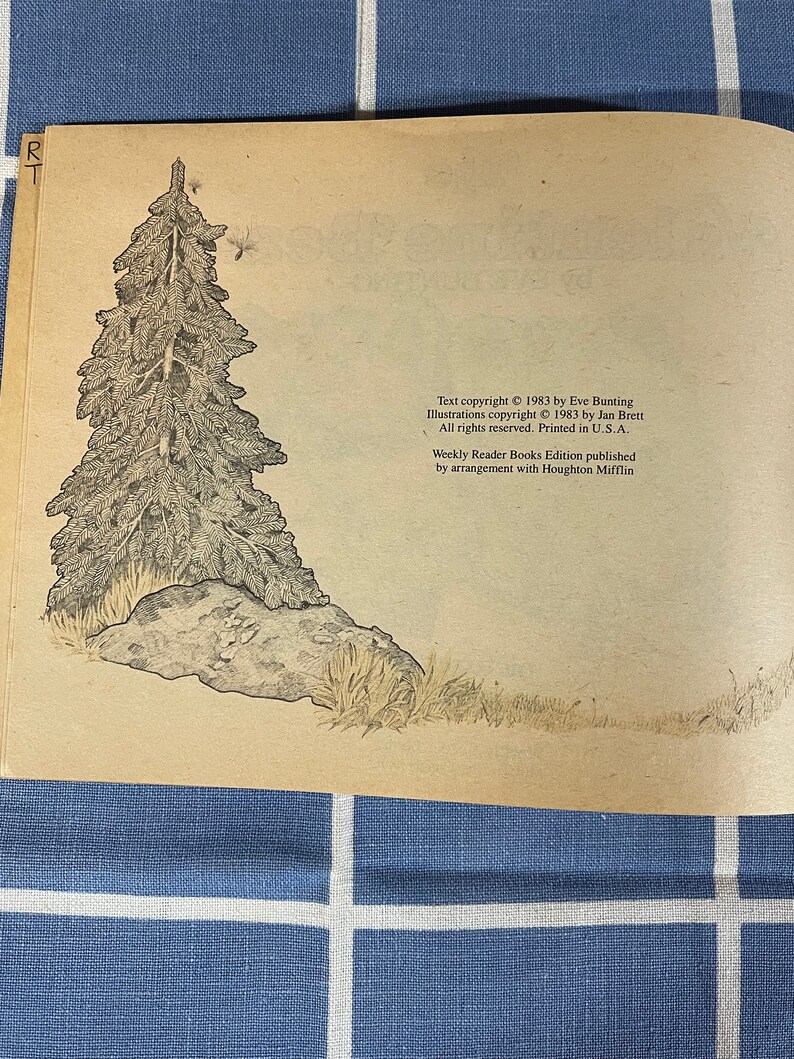 May include: A black and white illustration of a pine tree with a rock at its base. The illustration is on a light brown background with text at the bottom of the page. The text reads: "Text copyright &copy; 1983 by Eve Bunting. Illustrations copyright &copy; 1983 by Jan Brett. All rights reserved. Printed in U.S.A. Weekly Reader Books Edition published by arrangement with Houghton Mifflin."