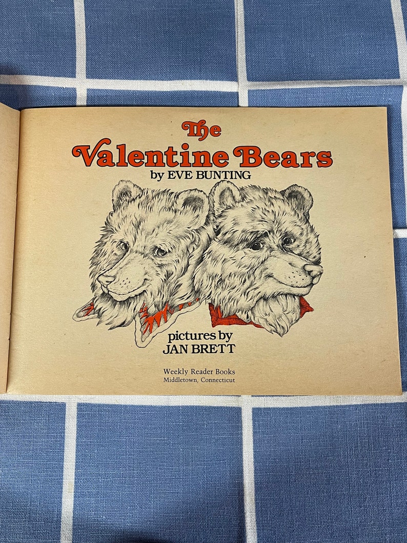May include: The Valentine Bears book cover features two brown bears with red and white scarves. The book is by Eve Bunting and illustrated by Jan Brett. The book is published by Weekly Reader Books in Middletown, Connecticut.
