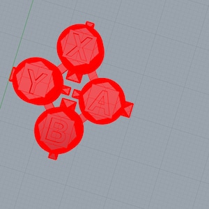 以下が含まれることがあります： X、Y、A、Bの文字が書かれた赤いプラスチックボタン。ボタンは円形に配置されています。