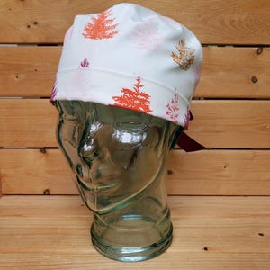 May include: White scrub hat with a colorful tree print. The hat has a burgundy tie.