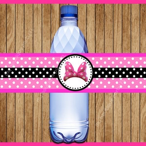 May include: Pink and black polka dot water bottle label with a white bow and red center. The label has a black border and a white circle around the bow.