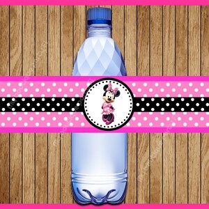 May include: Pink and black polka dot water bottle label with a Minnie Mouse character in a pink dress and white polka dots. The label has a black stripe with white polka dots.