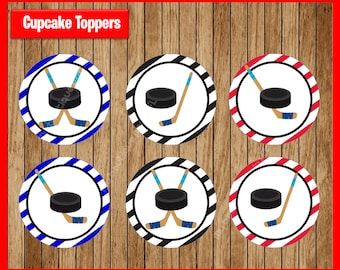 Op de afbeelding: Zes ronde cupcake-toppers met een hockeypuck en twee gekruiste hockeysticks. De toppers hebben verschillende gekleurde strepen: blauw en wit, zwart en wit en rood en wit.