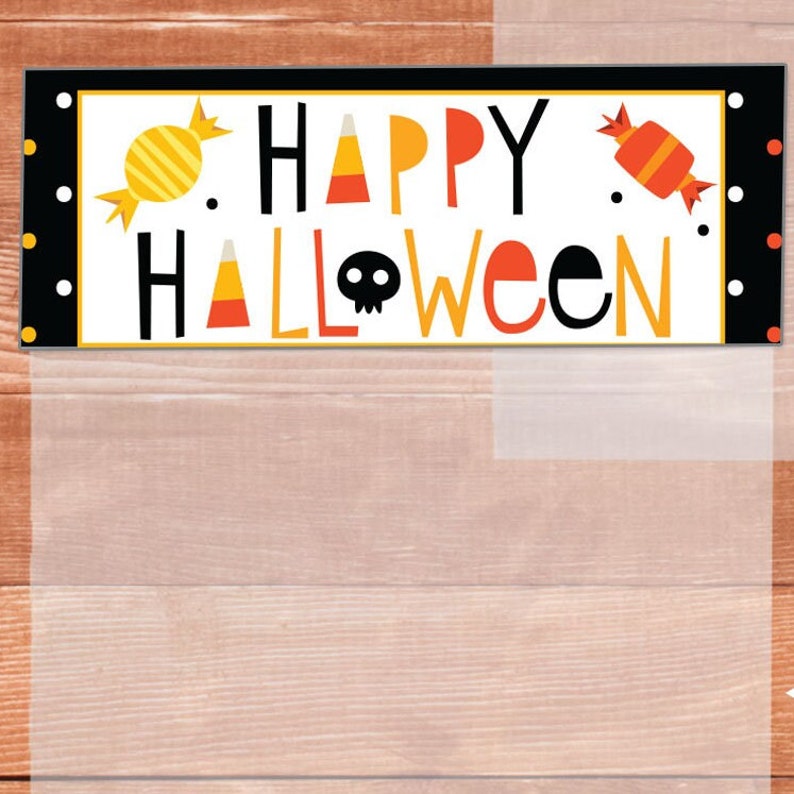 May include: A black and white banner with the text "Happy Halloween" in yellow and orange letters. The banner has a white background with candy corn and candy designs.