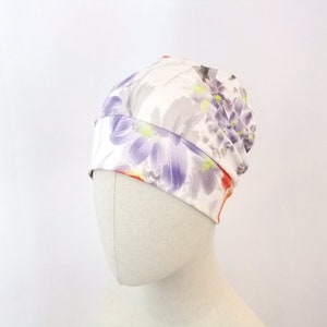 Summer chemo hat for a woman, orange and purple flowers on natural background