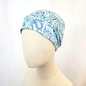 Può includere: Un berretto blu chiaro e bianco con un motivo paisley.
