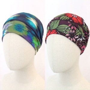 Può includere: Due fasce per capelli, una con un motivo astratto blu e verde e l'altra con un motivo floreale in tonalità di rosso, rosa, verde e marrone.