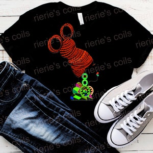 May include: Black t-shirt featuring a vibrant graphic of a woman's profile with orange coils and colorful geometric earrings. The shirt is paired with dark blue jeans and gray canvas sneakers.