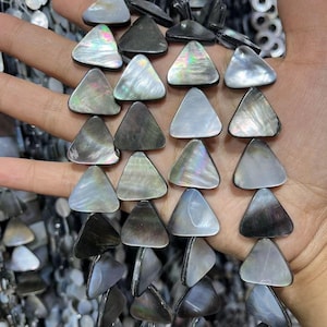 Puede incluir: Una hebra de cuentas de concha triangulares negras iridiscentes. Las cuentas tienen un aspecto natural y orgánico y son perfectas para la elaboración de joyas.