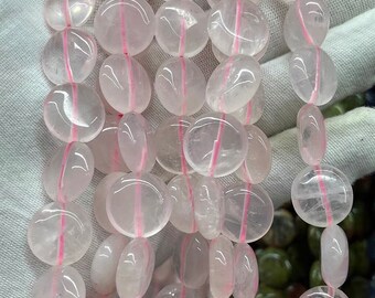 May include: A strand of translucent pink quartz beads with a smooth, rounded shape. The beads have a subtle pink hue and a natural, polished finish.