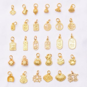 May include: A collection of 30 gold-colored charms with various Chinese characters and symbols. The charms are arranged in rows on a white background.