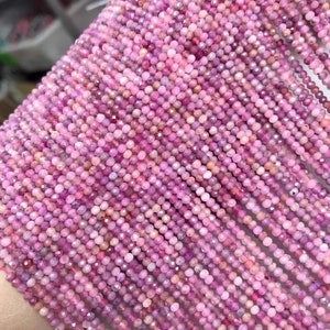 May include: A strand of pink ruby beads, each bead is faceted and measures approximately 2mm in diameter. The beads are strung on a clear thread and are ready to be used for jewelry making.