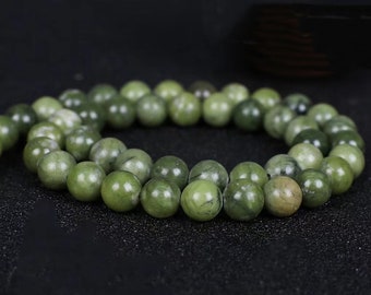 May include: A strand of green jade beads. The beads are round and smooth, and they have a natural, earthy look.