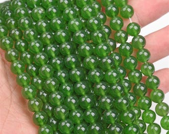 May include: A strand of round, green jade beads. The beads are smooth and polished, with a slight sheen.