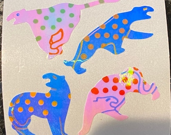 May include: Four colorful stickers featuring stylized animal designs. The stickers include a pink cheetah with green polka dots, a blue cheetah with orange polka dots, a blue animal with orange polka dots, and a pink animal with red polka dots.
