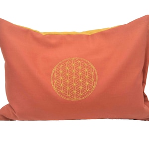Almohada de energía de color anaranjado con la flor de la vida