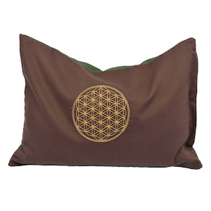 Peut inclure: Un oreiller brun avec un dos vert et un motif de fleur de vie brodé en or.
