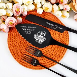 Op de afbeelding: Zwarte huwelijks taartmes en server set met de tekst "Till death do us part" en de datum "12.25.25" gegraveerd op de server. Het mes en de server liggen op een gehaakte oranje onderzetter.