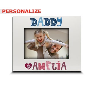 May include: White picture frame with a blue and white patterned "Daddy" and a pink and white patterned "& Amelia" at the top and bottom of the frame. A photo of a father and daughter is in the frame.