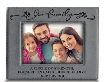 May include: Gray leather picture frame with a black engraved inscription that reads "Our family, A circle of strength, founded on faith... joined in love... kept by God". The frame has a photo of a family of four.