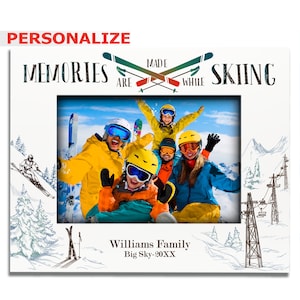 May include: White photo frame with a family of skiers in the photo. The frame has a white background with the text "Memories are made while skiing" and a drawing of skis. The text "Williams Family Big Sky - 20XX" is at the bottom of the frame.