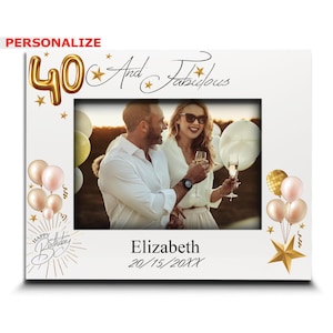 May include: White photo frame with a gold 40 and stars. The text "And Fabulous" is written in cursive. The frame has a photo of a couple toasting with champagne. The text "Happy Birthday" is written in cursive with gold stars. The text "Elizabeth 20/15/20XX" is written below the photo.