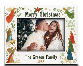 May include: White Christmas-themed picture frame with a photo of a couple kissing. The frame features the text "Merry Christmas", "Peace on Earth and Goodwill to All", and "The Grason Family 20XX". Decorative illustrations include angels, stars, and nativity figures.