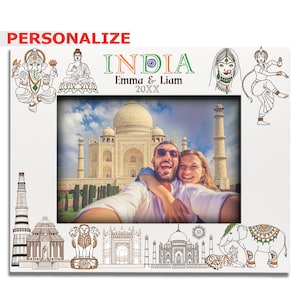 May include: A white photo frame with a white background and a picture of a couple in front of the Taj Mahal. The frame is decorated with Indian-themed illustrations, including an elephant, a tiger, and the Taj Mahal. The text "INDIA" is written in large letters at the top of the frame, and the text "Emma & Liam 20XX" is written below it.