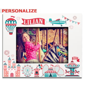 May include: A personalized photo frame with a carnival theme. The frame features a hot air balloon, a Ferris wheel, a roller coaster, a carousel, and a castle. The frame is white with red, blue, and green accents. The text "Lilian" is printed on the frame.