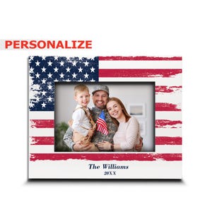 May include: A rectangular picture frame featuring a distressed American flag pattern in red, white, and blue. The frame displays a photograph of a family and includes the printed text "The Williams" and "20XX" at the bottom center.