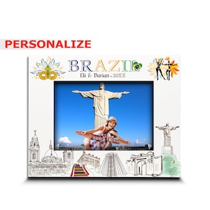 May include: A white photo frame with a colorful border featuring a Brazilian flag, a carnival mask, and dancers. The frame has a photo of a couple in front of the Christ the Redeemer statue in Rio de Janeiro. The text "BRAZIL" and "Eli & Darian - 20XX" is printed on the frame.