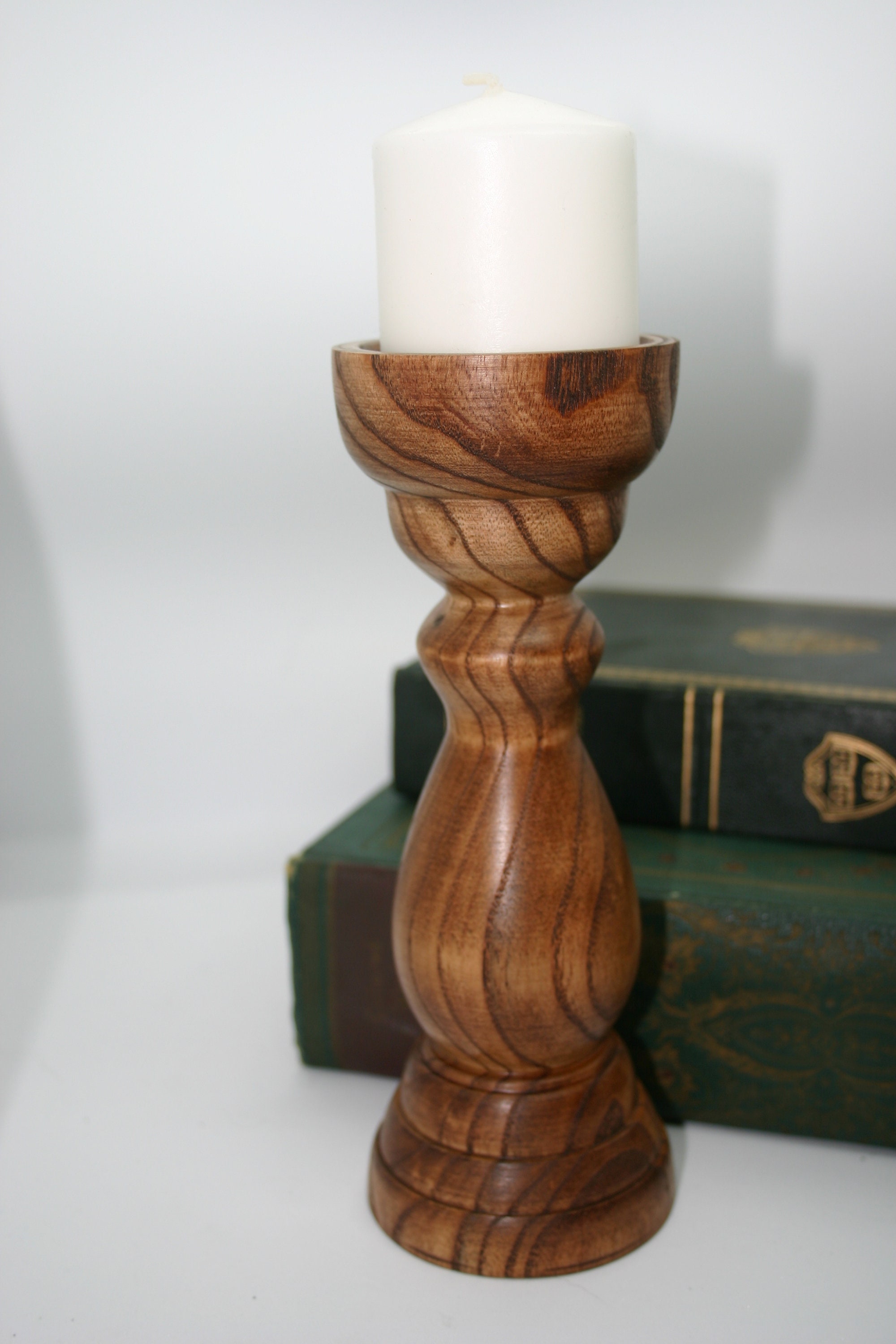 A hand turned Pine candle holder with a lite oak finish. Candle Stick