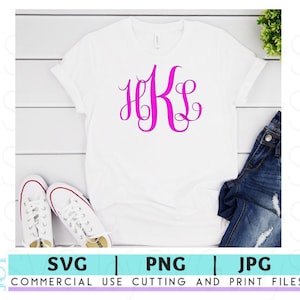 May include: A white t-shirt with a pink monogram of the letters "HKS" on the front. The shirt is laid flat on a white wooden surface with a pair of white sneakers and a pair of blue jeans.