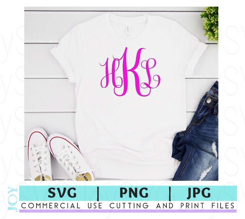 May include: A white t-shirt with a pink monogram of the letters "HKS" on the front. The shirt is laid flat on a white wooden surface with a pair of white sneakers and a pair of blue jeans.