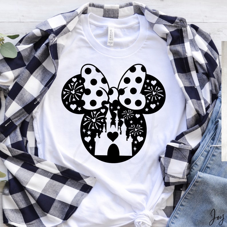 May include: White t-shirt with a black silhouette of Mickey Mouse ears with a bow and a castle inside the ears. The bow has white polka dots. The castle has a heart in the center. There are fireworks and stars around the castle.