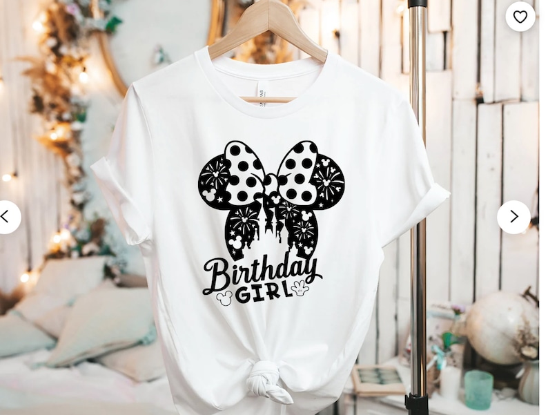 May include: White t-shirt with a black and white Minnie Mouse ears design and the text "Birthday Girl".