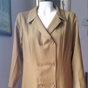 May include: A long, double-breasted, olive green coat with a V-neck collar and four buttons down the front.