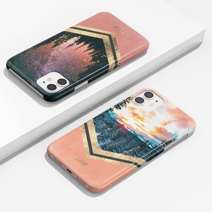 Peut inclure: Deux coques de t&eacute;l&eacute;phone avec un fond rose et des accents dor&eacute;s. Une coque pr&eacute;sente un ciel &eacute;toil&eacute; de nuit avec des arbres au premier plan. L'autre coque pr&eacute;sente un coucher de soleil sur une cha&icirc;ne de montagnes avec des arbres au premier plan. Les deux coques portent l'inscription "KaseMe".