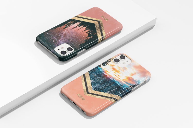 Peut inclure: Deux coques de t&eacute;l&eacute;phone avec un fond rose et des accents dor&eacute;s. Une coque pr&eacute;sente un ciel &eacute;toil&eacute; de nuit avec des arbres au premier plan. L'autre coque pr&eacute;sente un coucher de soleil sur une cha&icirc;ne de montagnes avec des arbres au premier plan. Les deux coques portent l'inscription "KaseMe".