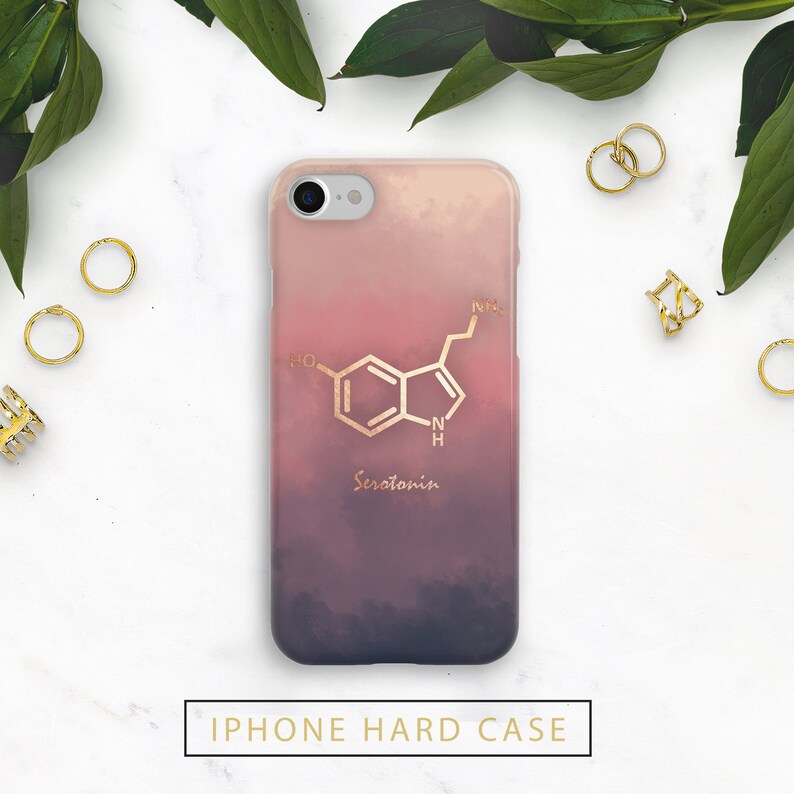 May include: A hard iPhone case with a gradient design of pink, purple, and white. The case features a gold-colored serotonin molecule graphic and the word "Serotonin" in gold. The text "IPHONE HARD CASE" is at the bottom.