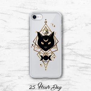 Peut inclure: Une coque de t&eacute;l&eacute;phone transparente avec un chat noir et un motif g&eacute;om&eacute;trique dor&eacute;. Le chat a un croissant de lune sur le front et le motif comprend un symbole de triple lune. Le texte "25 Hour Day" est imprim&eacute; sous la coque.