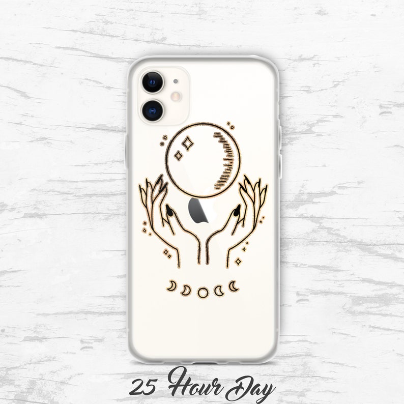 May include: A clear phone case with a gold outline design of two hands holding a crescent moon with stars. The text "25 Hour Day" is printed below the design.