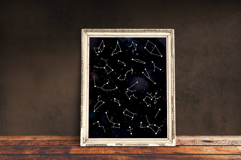 May include: A framed print of constellations on a black background with white lines and dots. The frame is silver with a decorative border.