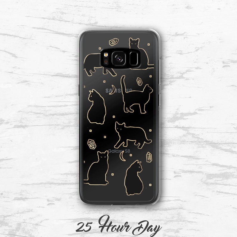 May include: A clear phone case with a black background and gold outlines of cats and crystals. The text "Galaxy S8" is visible in the bottom center of the case.