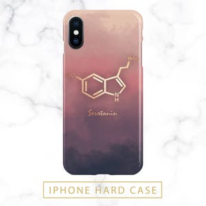 May include: iPhone hard case with a gradient design in shades of pink, red, and navy blue. The case features a gold-colored serotonin molecule graphic and the word "Serotonin" in a matching gold font.