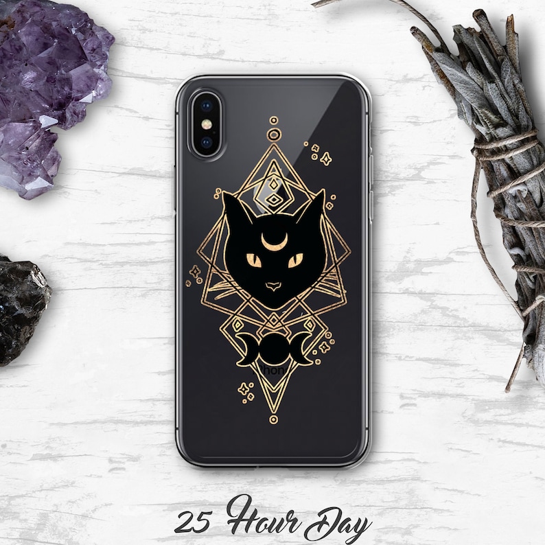 Peut inclure: Une coque de t&eacute;l&eacute;phone transparente avec un motif de silhouette de chat noir. Le chat a un croissant de lune sur le front et est entour&eacute; d'un motif g&eacute;om&eacute;trique dor&eacute;. Le texte "25 Hour Day" est imprim&eacute; sous la coque.